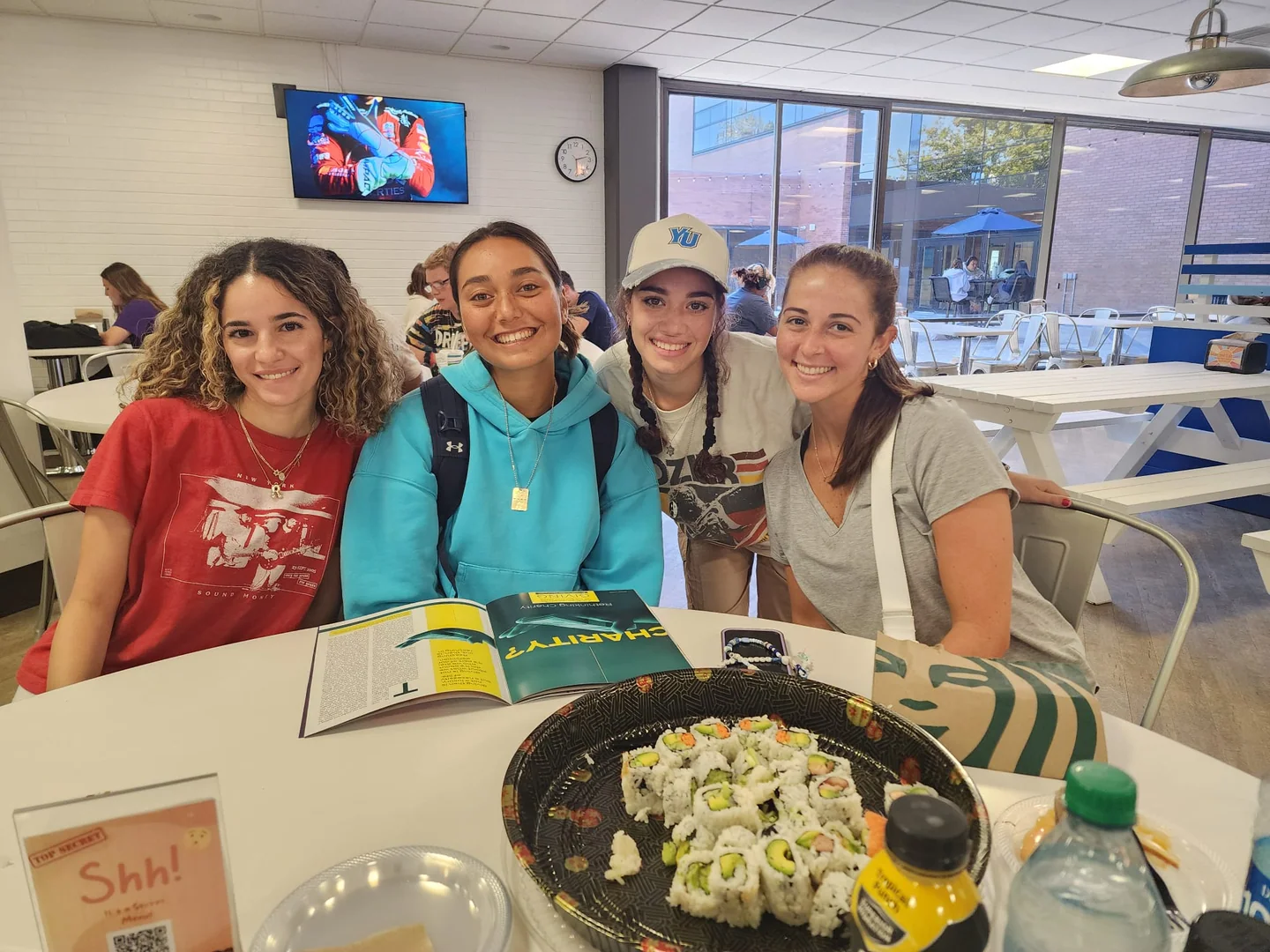 Four Monmouth students together with a Jewish learning book open on the table